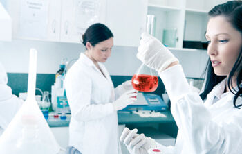 Researcher holding a flask with red liquid