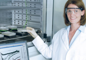 Woman placing plate on SDR in incubator